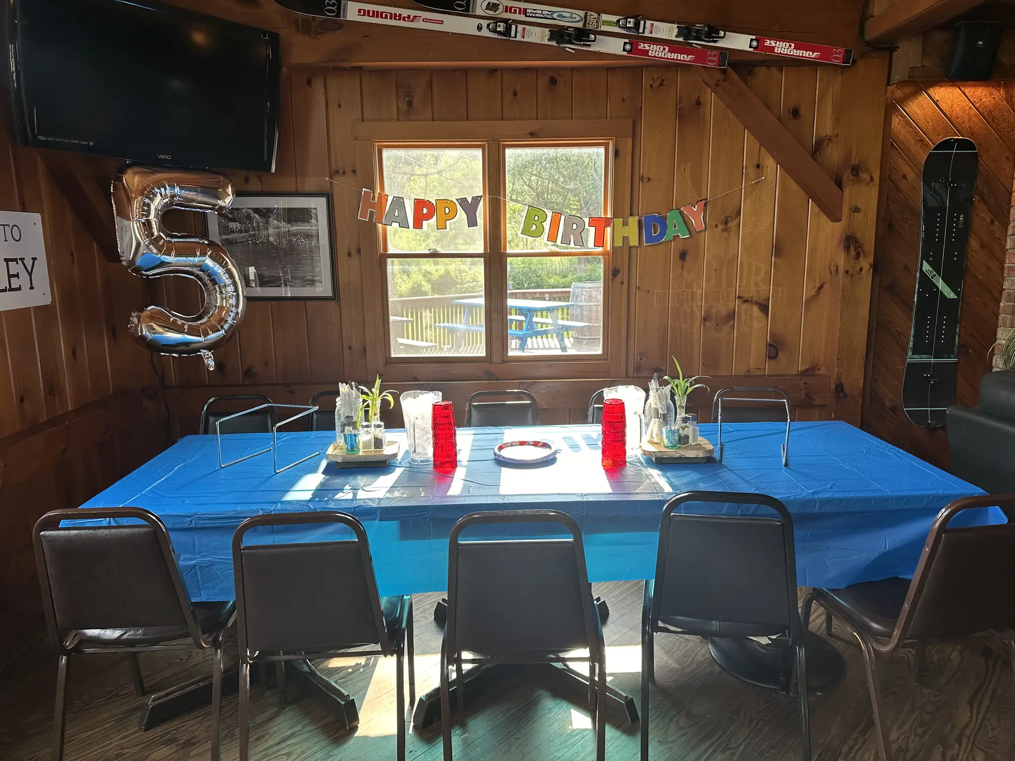 Birthday party setup with blue tablecloth and festive decorations