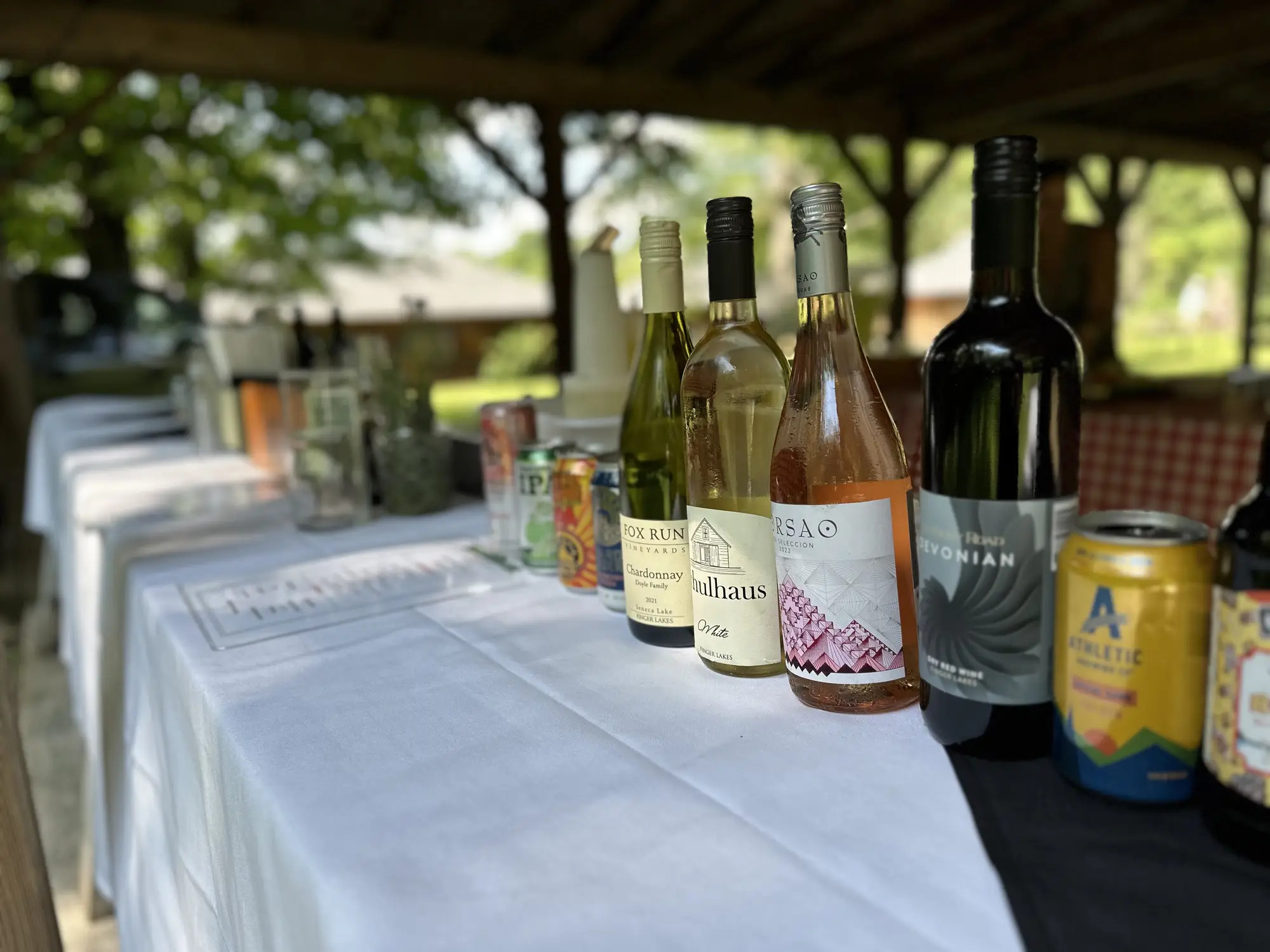 Outdoor bar setup with variety of wines and canned beverages