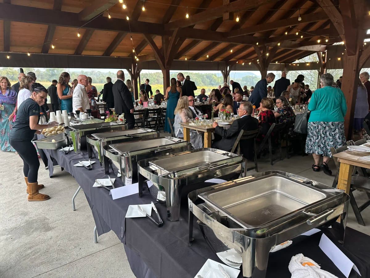 Outdoor pavilion event with buffet stations and guests