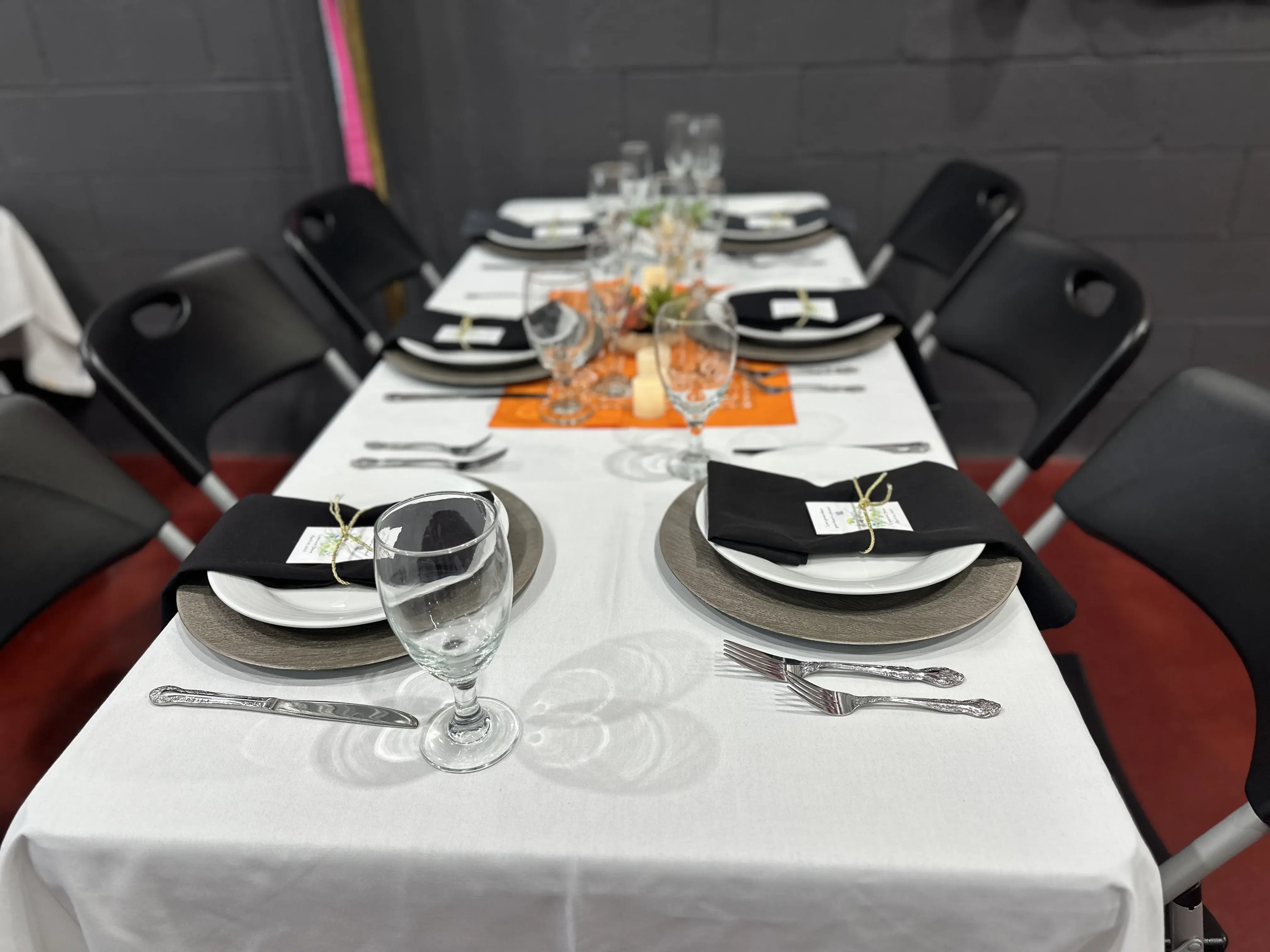 Small table setting with orange floral centerpiece