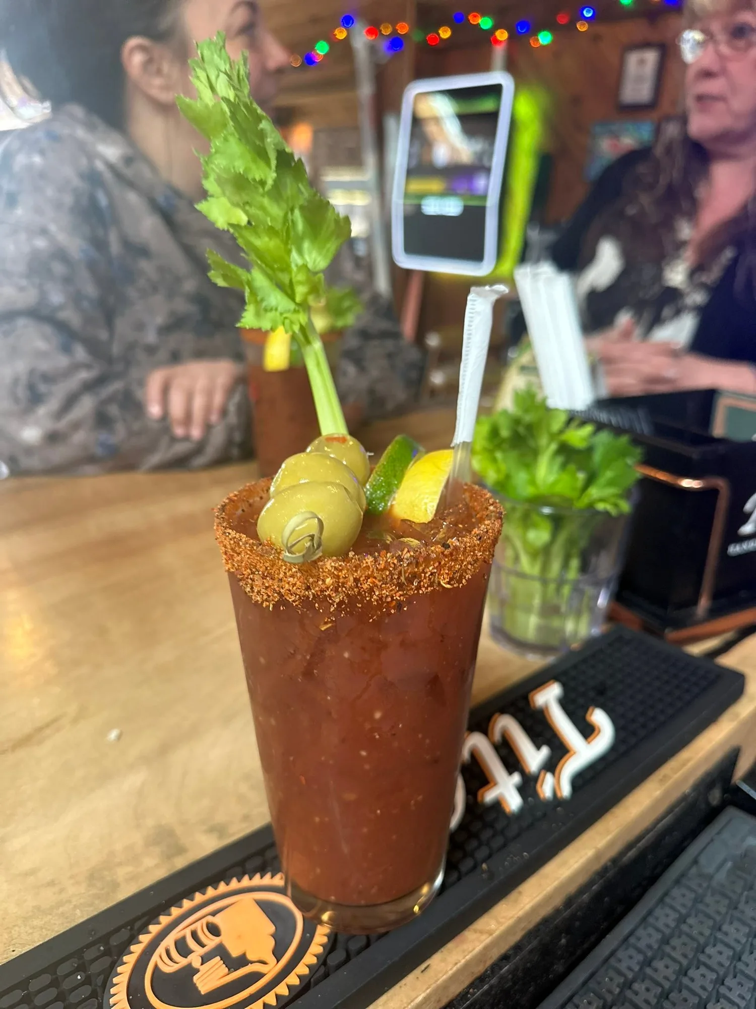 Bloody Mary with spiced rim, celery and olives on the bar