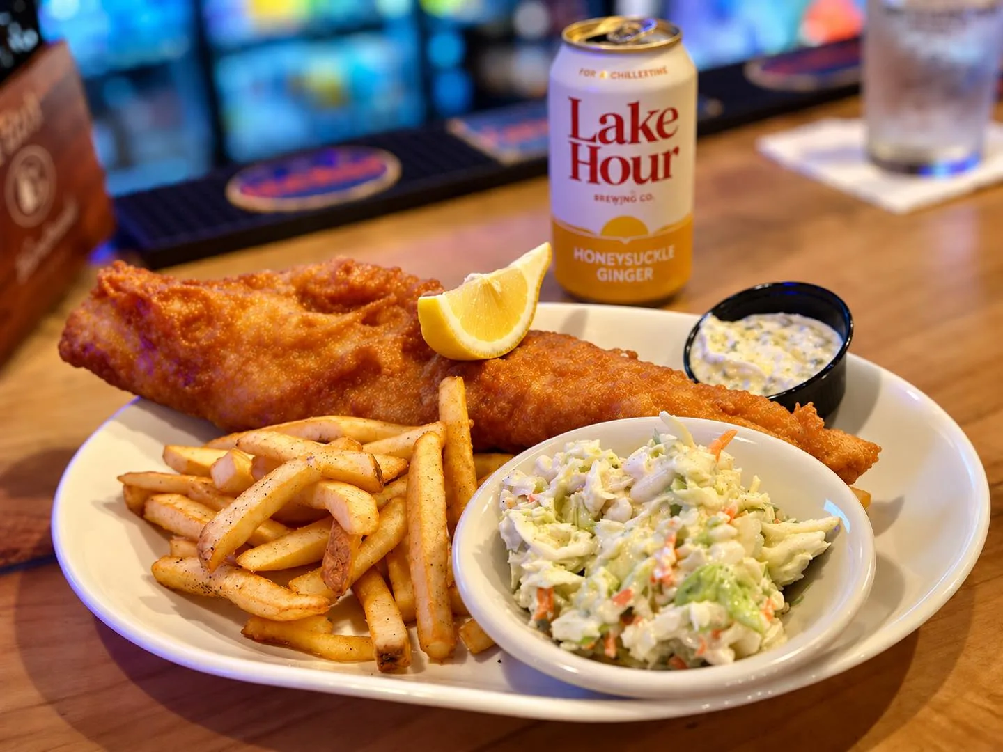 Beer-battered haddock with fries, coleslaw and tartar sauce on the bar
