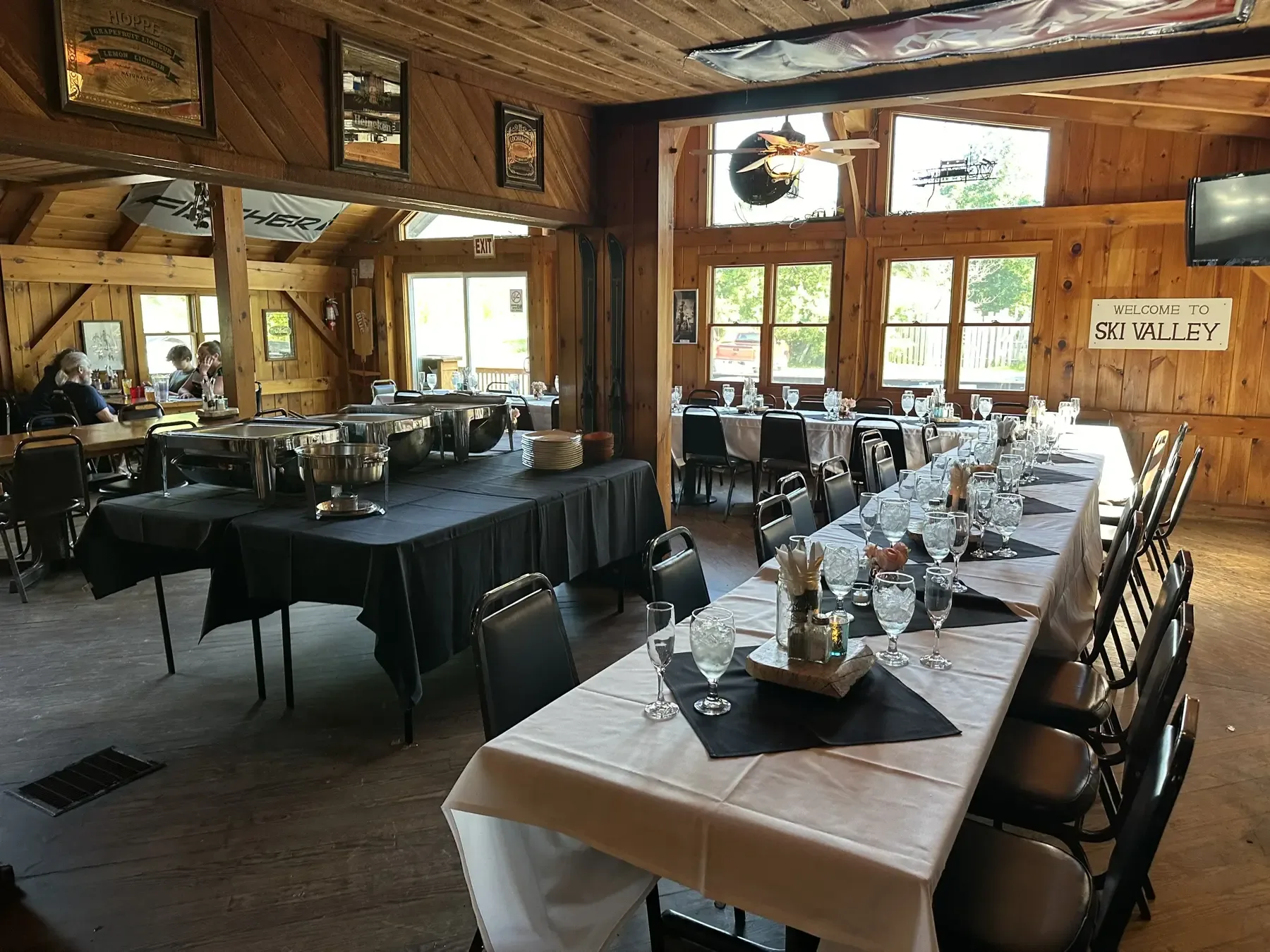 Lodge dining room with a long table set for a private event and a buffet line
