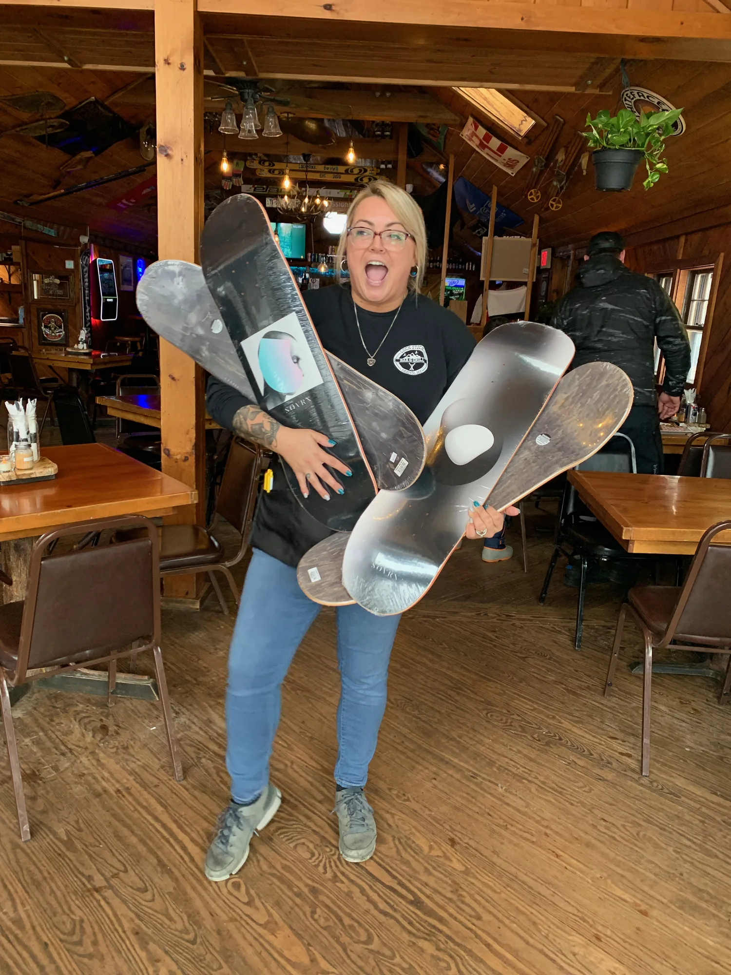 Excited server holding an armful of skateboard decks in the dining room